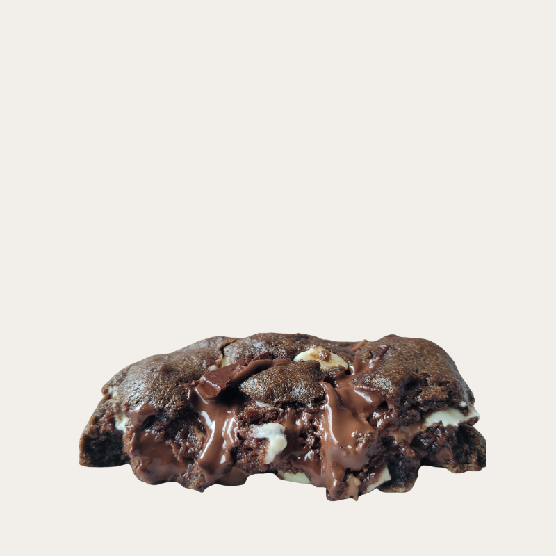 Triple Chocolate Chunk Cookie cross-section showing molten dark, milk, and white Belgian chocolate with a soft fudgy center.